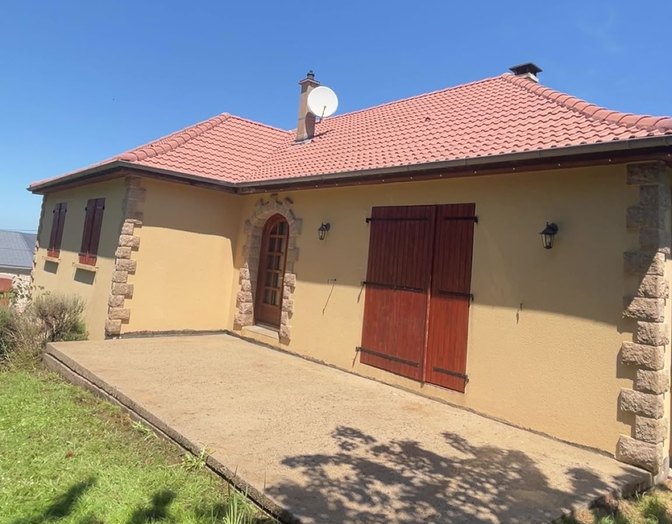 Après : maison à façade jaune, toit de tuiles et arche en pierre